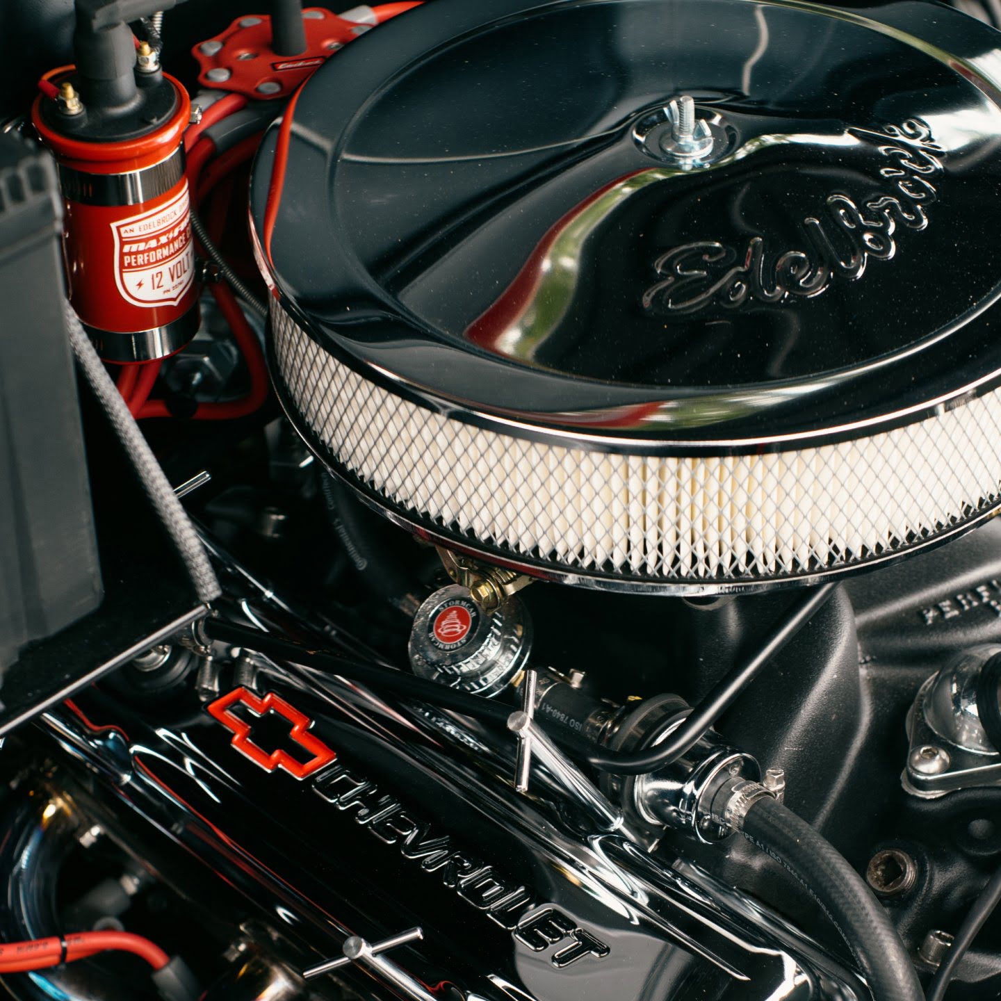 A close up of a very clean and shiny engine bay. The engine air intake has the extruded lettering saying Edelbrock