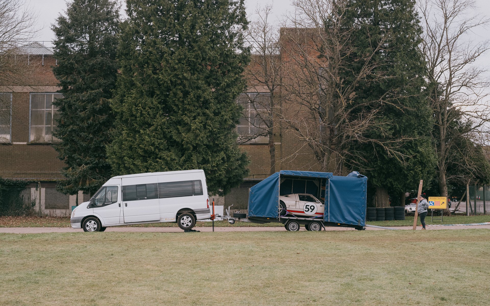 A photo of a classic car being transported on the back of a trailer.